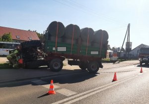 Przewrócony ciągnik z przyczepą pełną balotów