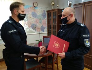 Pełniący obowiązki Komendanta Powiatowego Policji w Miliczu młodszy inspektor Mariusz Tański wręcza list pochwalny dzielnicowemu sierżantowi sztabowemu Jackowi Jaroszowi