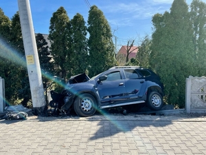 Uszkodzony samochód marki Dacia Duster po uderzeniu w betonowe ogrodzenie posesji w Cieszkowie