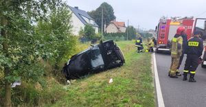 na zdjęciu pojazd w rowie oraz dwa wozy straży pożarnej