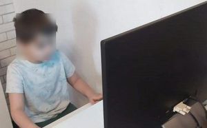 Mały chłopczyk siedzi przy monitorze komputera