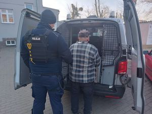 Policjant pilnuje zatrzymanego mężczyznę