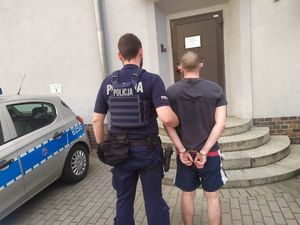 Policjant prowadzi zatrzymanego mężczyznę