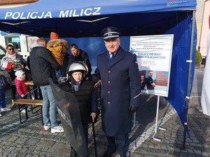 Komendant Powiatowy Policji w Miliczu inspektor Mariusz Tański z chłopcem ubranym w policyjny strój ochronny i hełm