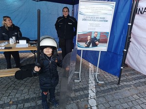 Chłopczyk ubrany w hełm policyjny