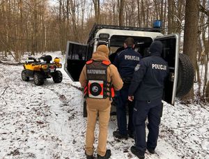 policjanci oraz ratownik na tle quada i radiowozu