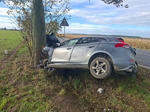 Miejsce zdarzenia drogowego - osobowe Volvo po uderzeniu w przydrożne drzewo