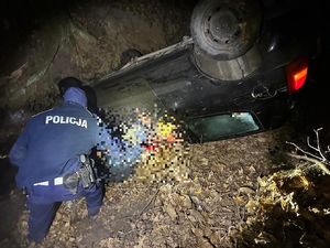 Policjant obok rozbitego pojazdu