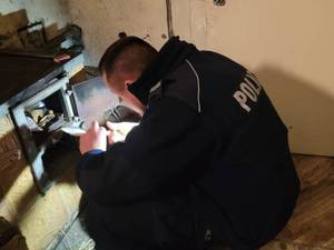 Policjant w trakcie rozpalania pieca