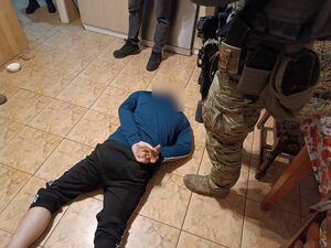 Zatrzymany mężczyzna, obok policyjni kontrterroryści