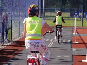 Dzieci jadące na rowerach w kaskach na głowie