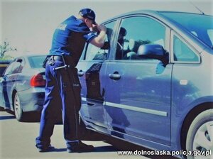 Zdjęcie poglądowe - policjant zagląda do samochodu