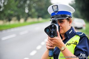Zdjęcie poglądowe - policjantka w trakcie kontroli prędkości jazdy pojazdów