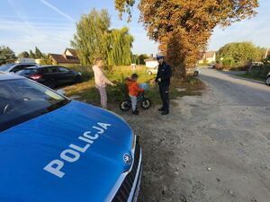 Policjant wręcza dziecku kask