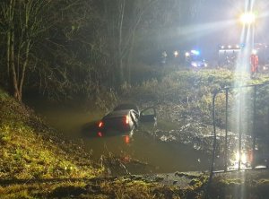 Ford Focus zanurzony w rzece, obok na drodze stoją wozy służb ratunkowych