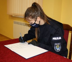 Policjantka podpisuje akt ślubowania