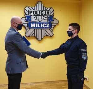 Komendant Powiatowy Policji w Miliczu p. o. podinspektor Marek Sroczyński gratuluje posterunkowemu Konradowi Nowostawskiemu