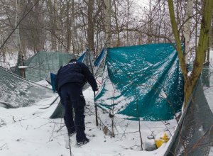 Policjant kontroluje miejsce, gdzie mogą przebywać osoby bezdomne