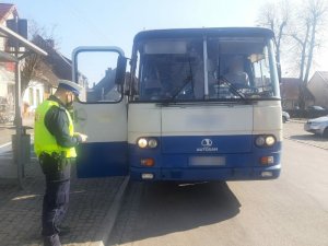 Policjant w trakcie kontroli autobusu kursowego