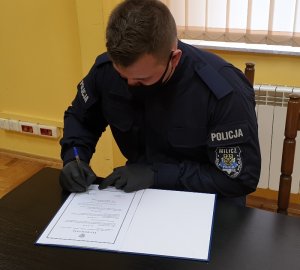 Policjant podpisuje akt ślubowania