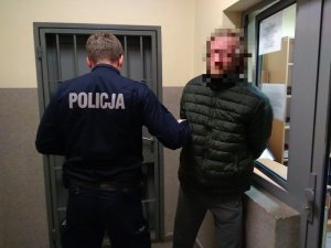 Policjant trzyma zatrzymanego nietrzeźwego mężczyznę