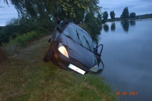 samochód osobowy marki ford częściowo zanurzony w stawie